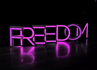 purple Freedom lighted freestanding letters on brown surface