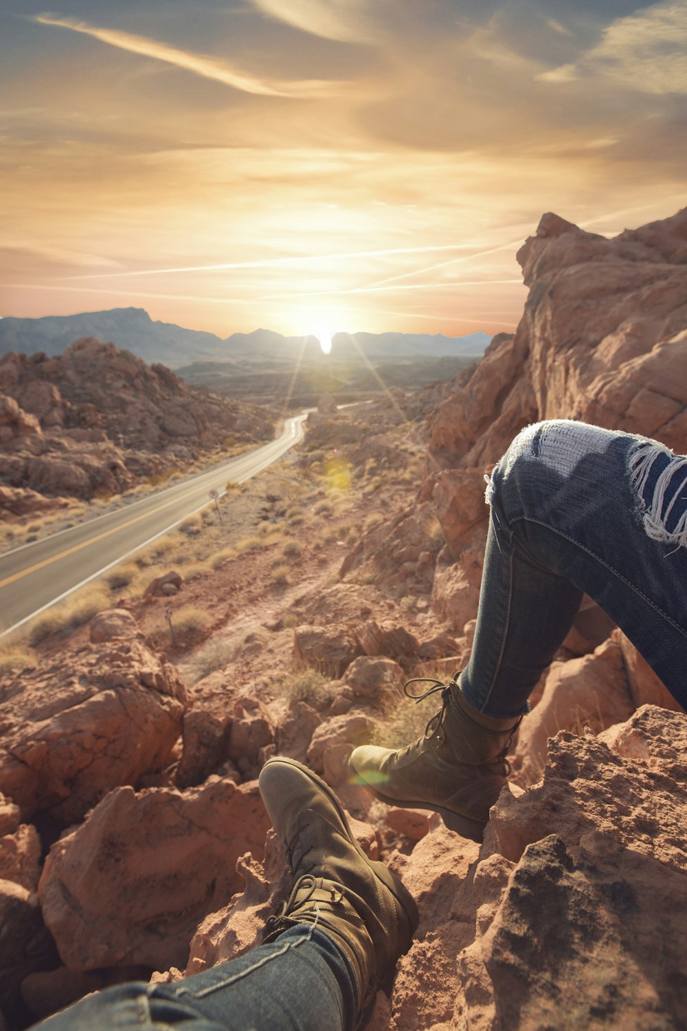 person sitting on rock formation cliff