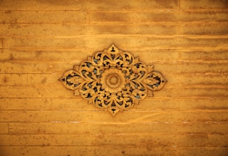 Close-up of a finely engraved wooden plaque with intricate floral patterns.