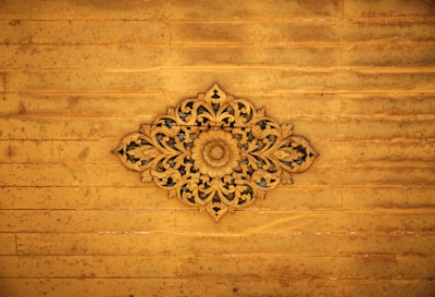 A skilled artisan carving intricate floral patterns on a solid wood panel.