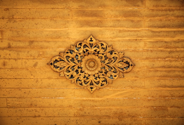 A close-up of a finely carved wooden wall panel with intricate floral patterns.