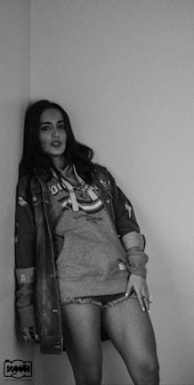 Model wearing a classic denim jacket against an urban brick wall.