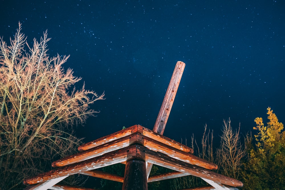 brown wooden frame beside tree during night time