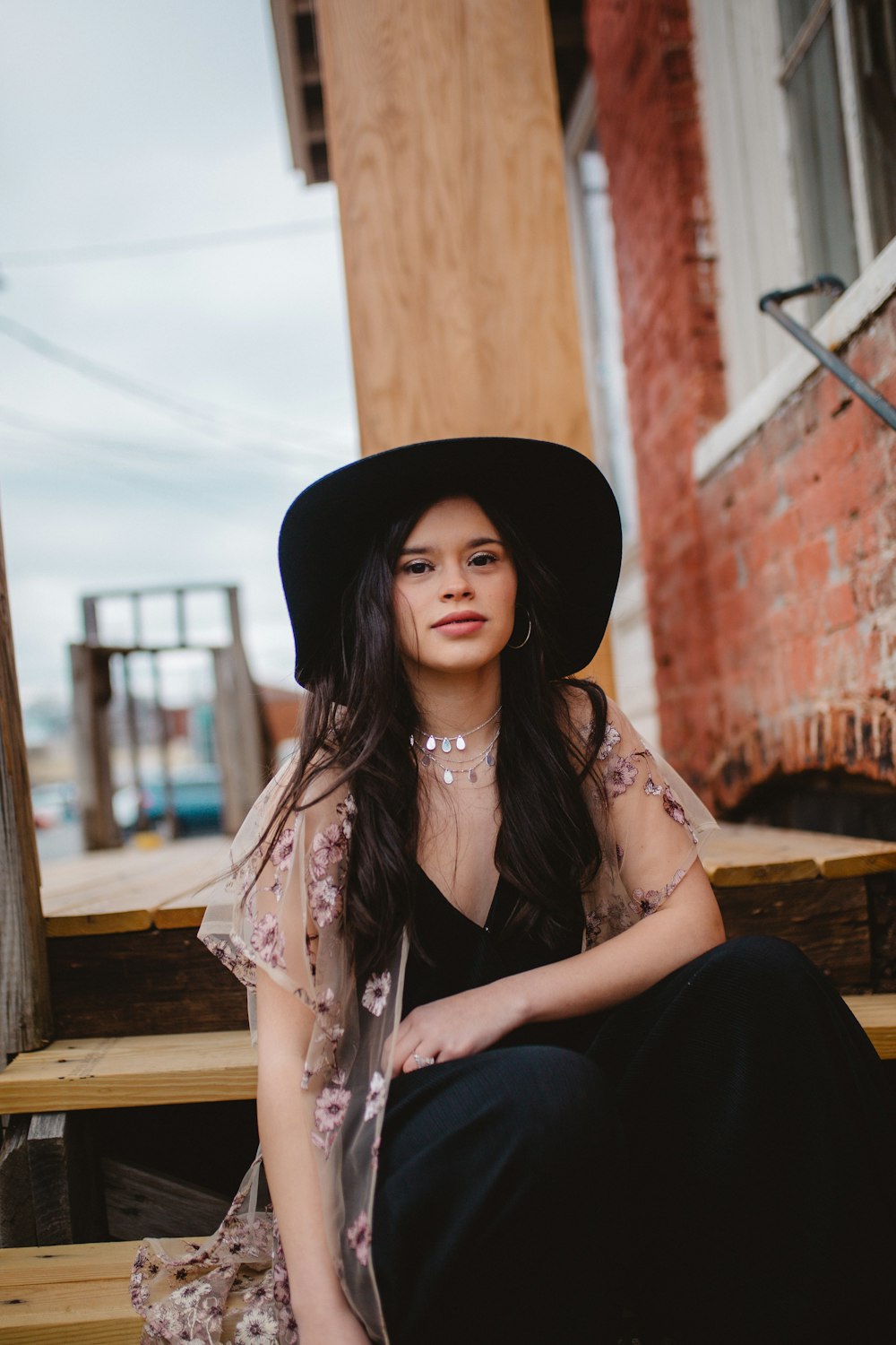 woman sitting on brown wooden stairs