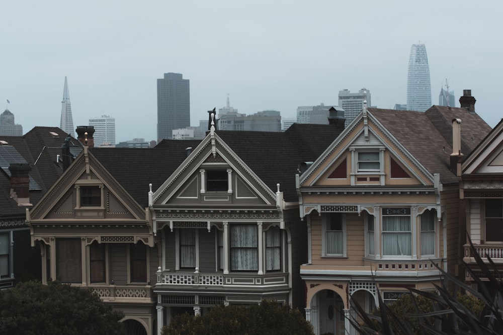 Tres casas de hormigón gris y beige bajo el cielo nublado durante el día