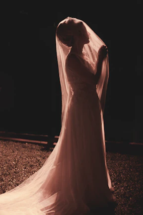 A radiant bride smiling softly under natural light during a golden hour wedding shoot.