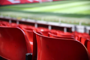 Close-up of a vibrant red and black RCB jersey draped over a stadium seat.