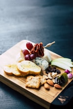 A variety of fresh and healthy snacks arranged on a wooden board.