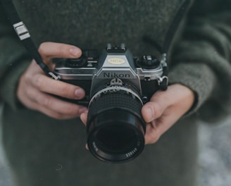 person holding black Nikon DSLR camera