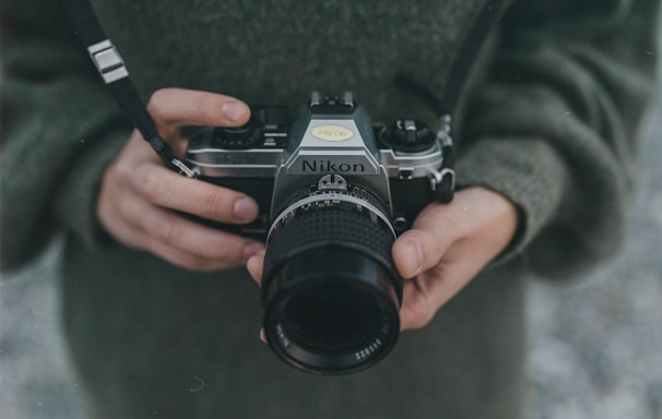 person holding black Nikon DSLR camera