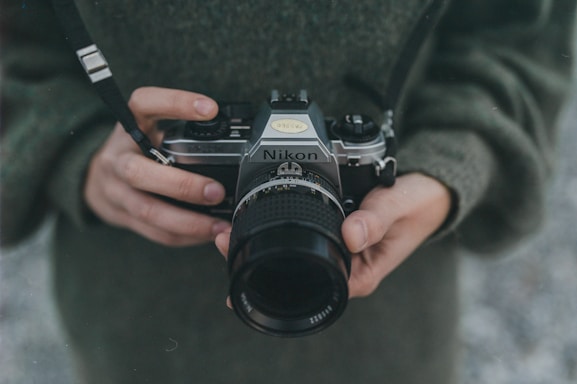 person holding black Nikon DSLR camera