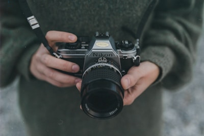 person holding black Nikon DSLR camera
