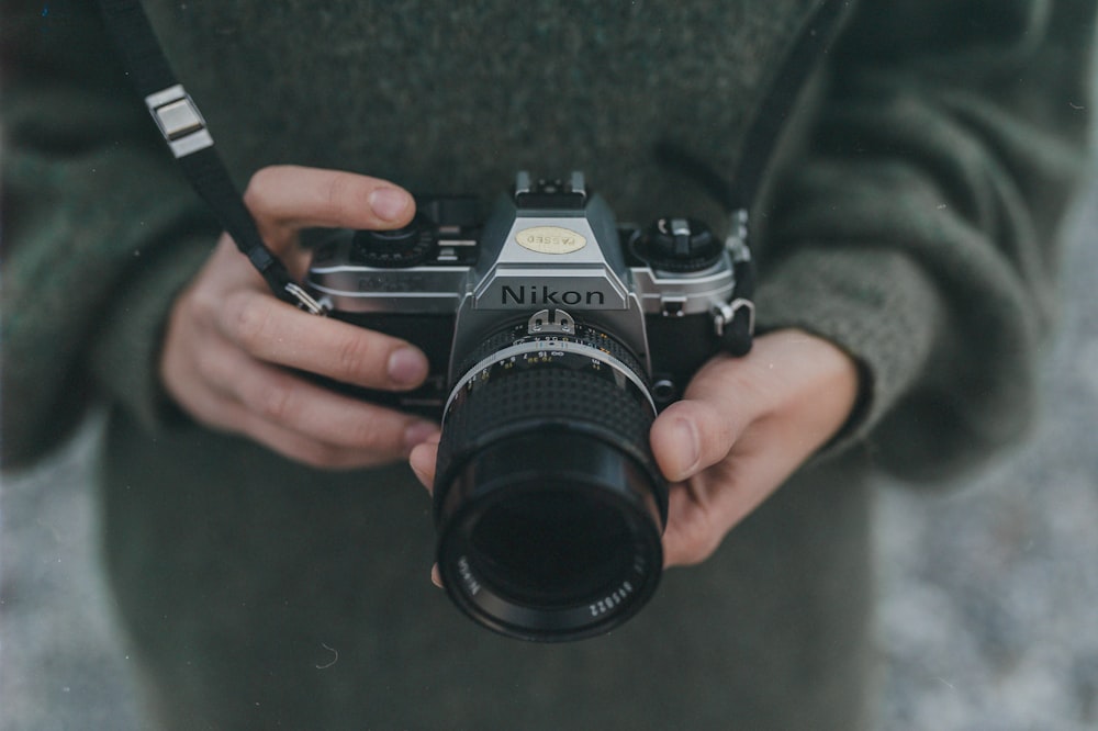 person holding black Nikon DSLR camera