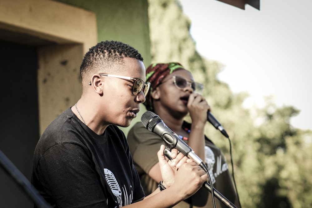 two persons holding microphones while talking