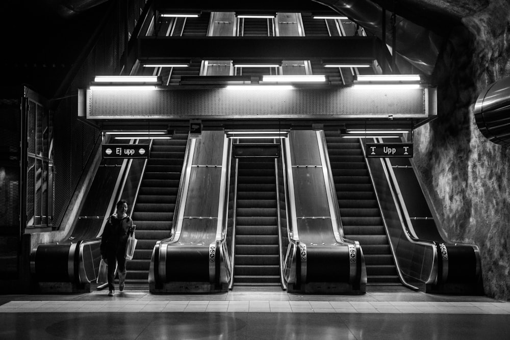 a person standing in front of an escalator