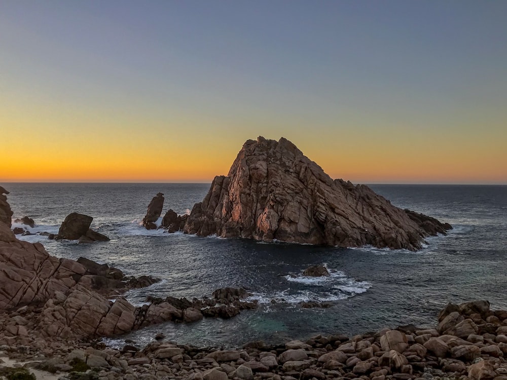 Formação rochosa no mar durante o pôr do sol