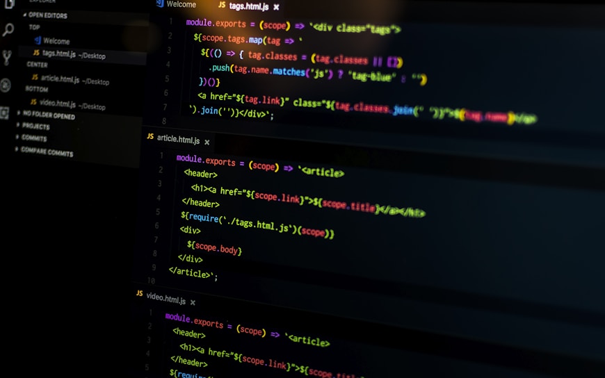 A computer screen displays various sections of code written in JavaScript. The code includes module exports and HTML tags within a text editor interface, which is divided into several panels. The text editor panel exhibits a dark theme with syntax highlighting, showing functions and variables.