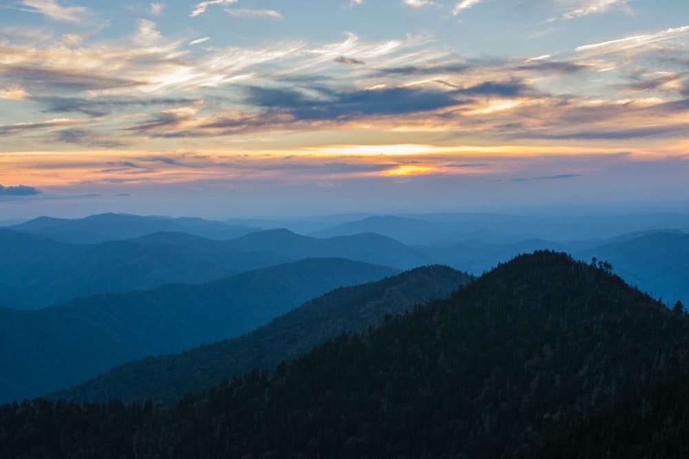 silhouette of mountain under white and yellow sky