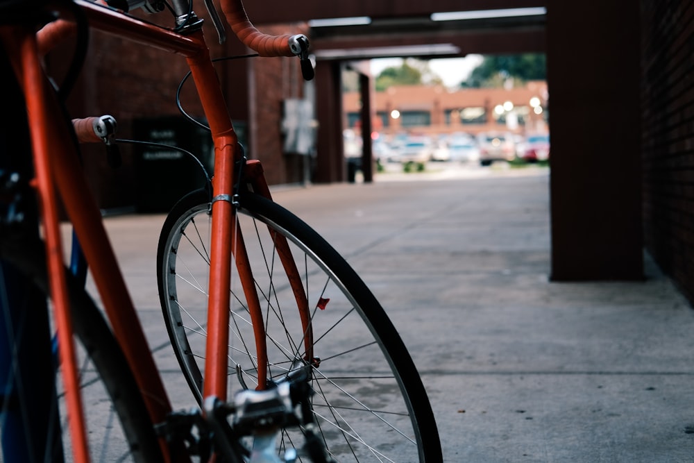 Bicicleta de carretera roja sobre pavimento gris