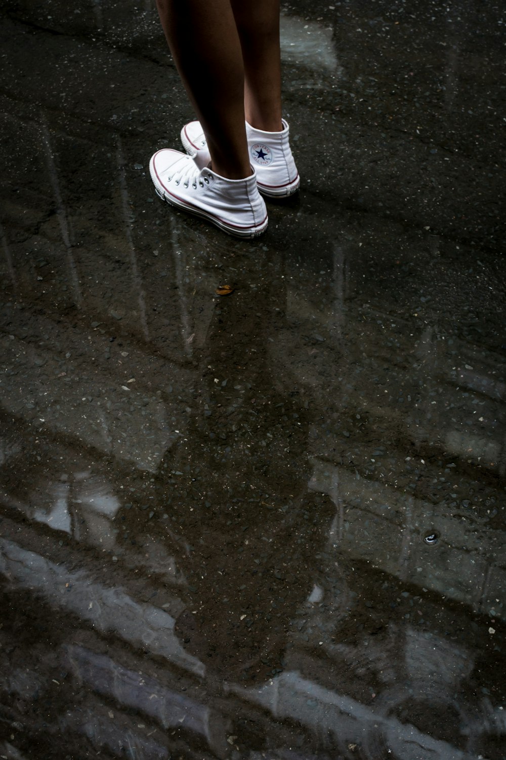 woman wearing pair of white Converse sneakers