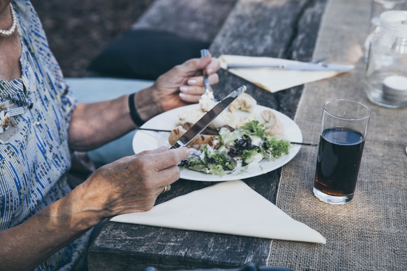 Senior woman preparing a healthy meal with fresh vegetables, dairy, and whole grains — a practical approach to bone-healthy eating for older adults