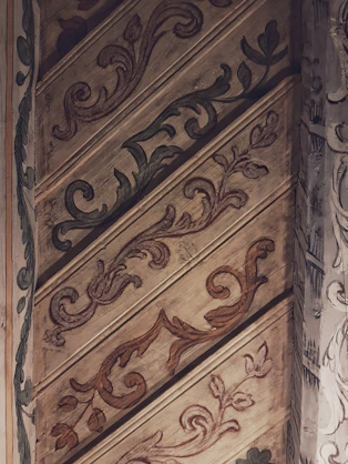 Golden wood panels engraved with delicate floral designs, showcasing fine laser precision.