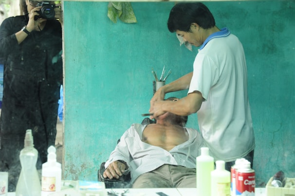 A client relaxing while receiving a clean shave in a cozy, family-friendly barber chair.