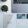 A minimalist workspace setup with a laptop in the top right corner and several business cards and a poster arranged neatly on a white desk. The cards display text and artistic designs, while two small potted plants add a touch of greenery to the setting.