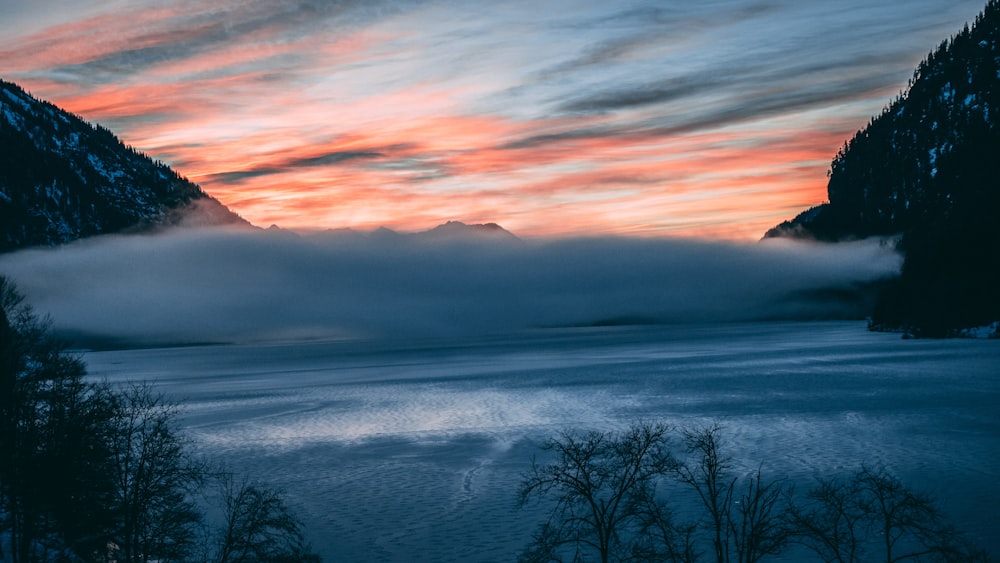 body of water surrounded by mountains photography