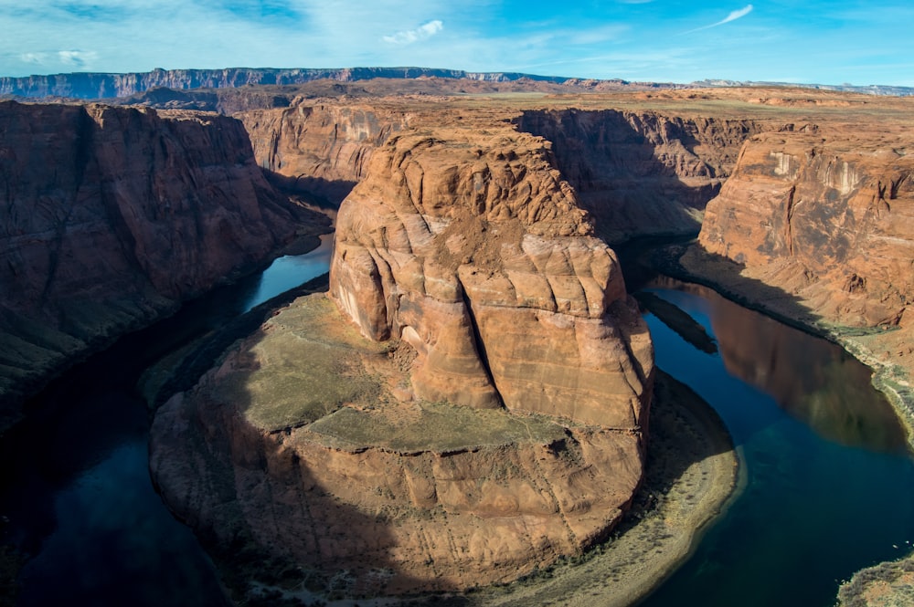 aerial photography of brown and green mountain surrounded by body of water during daytime