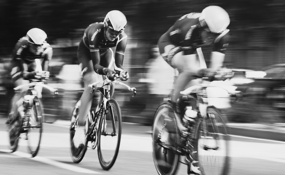 Fotografia de lapso de tempo de três homens pedalando