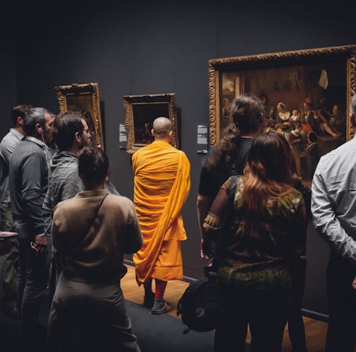 people standing in front of paintings