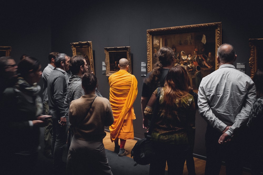 people standing in front of paintings