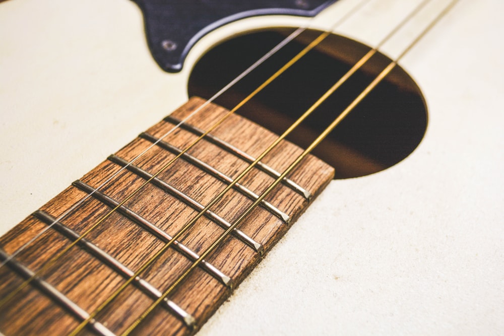 beige and brown acoustic guitar