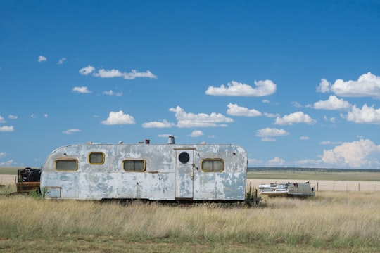 gray metal travel camper on grass land under blue and white cloudy skies at daytime in Encino United States