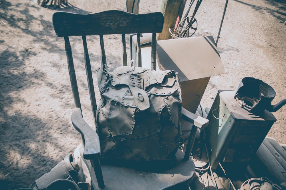 braune Ledertasche auf schwarzem Holzstuhl