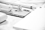 Apple AirPods on silver iPhone X beside Apple Pencil