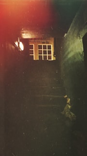 A historic mansion’s dimly lit hallway with flickering candlelight casting eerie shadows