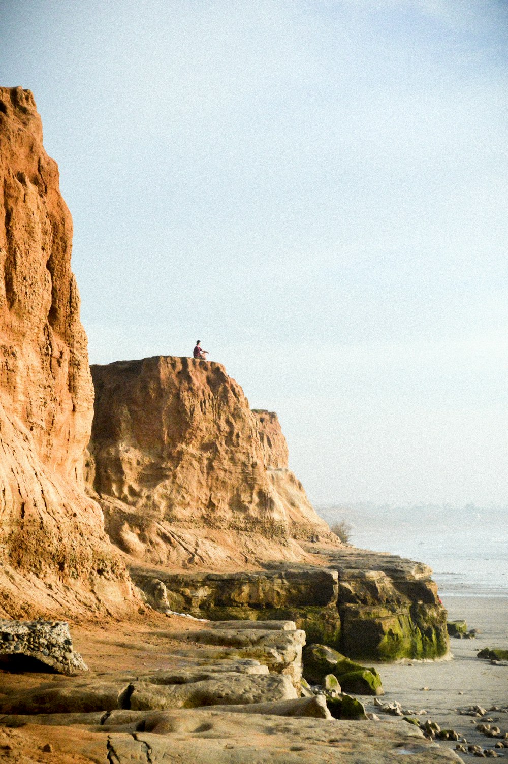 man on cliff near water