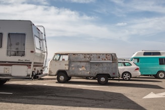 A fleet of diverse rental vehicles parked in a sunny location.