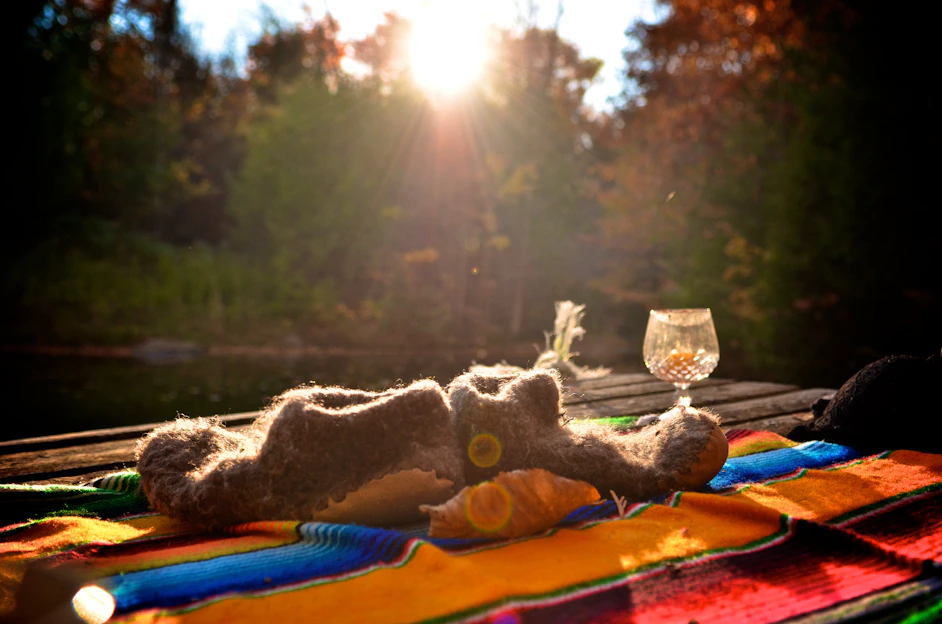 A cozy flat lay of a deep teal t-shirt and a warm gold hat resting on a rustic wooden surface.
