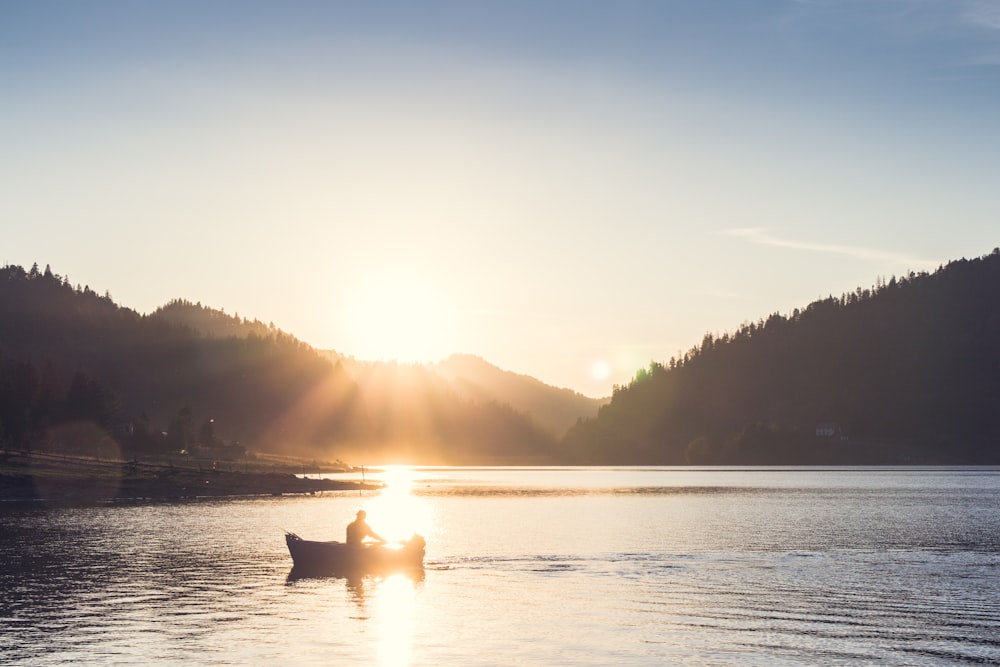 pessoa no barco navegando durante o pôr do sol