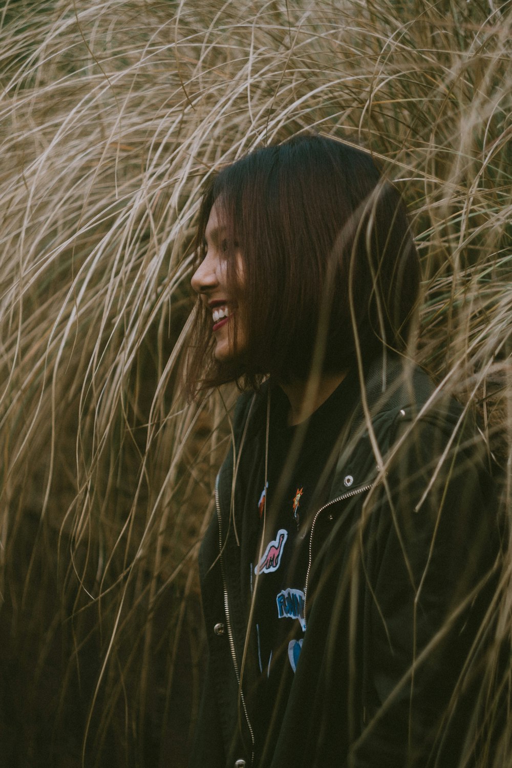 femme en veste noire souriant