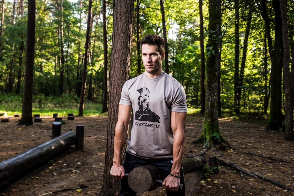 man on gray shirt holding brown and black log