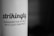 A close-up of black text printed on a white curved surface, with the text reading: 'strikingly' and 'CONQUER THE WORLD WITH JUST ONE PAGE'. The background fades into a dark gradient.