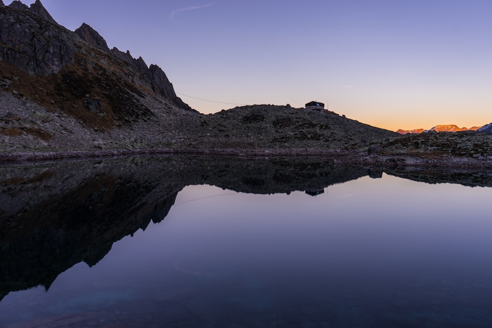 calm body of water beside mountain