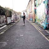A sleek, modern cartoon character skateboarding past graffiti walls.