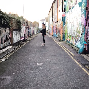 A sleek, modern cartoon character skateboarding past graffiti walls.
