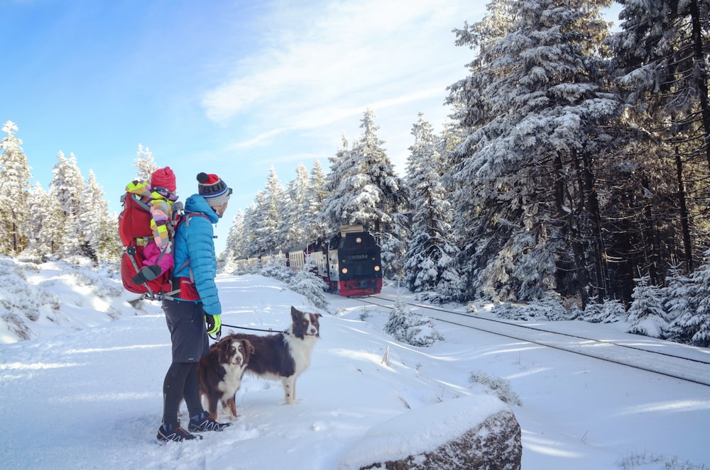 man and dog on snow terrain