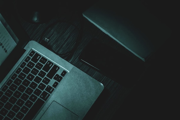A dark-themed workspace with a laptop and smartphone showing the Exponotes app interface under soft neon blue lighting.